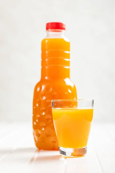 フルーツジュースのグラス 白いテーブルの上のオレンジジュース — ストック写真