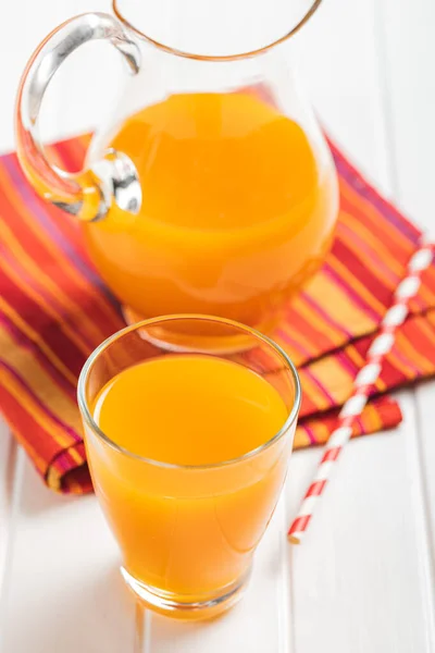 フルーツジュースのグラス 白いテーブルの上のオレンジジュース — ストック写真
