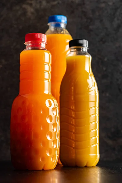 Plastovou Láhev Ovocného Džusu Pomerančový Džus Černém Stole — Stock fotografie