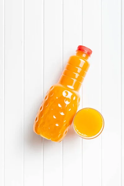 果物ジュースのペットボトル 白いテーブルの上にオレンジジュース トップ表示 — ストック写真