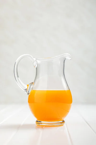Bir Sürahi Meyve Suyu Beyaz Masada Portakal Suyu — Stok fotoğraf