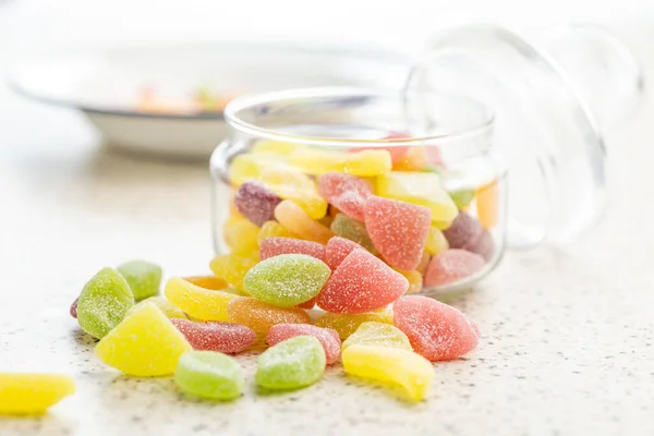 Mix of fruity jelly candy in jar on the kitchen table.