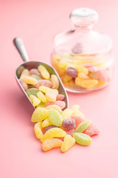 粉红背景的勺子里混合着果冻糖 — 图库照片