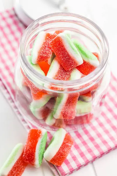 Watermelon jelly candies  in jar on the kitchen table.