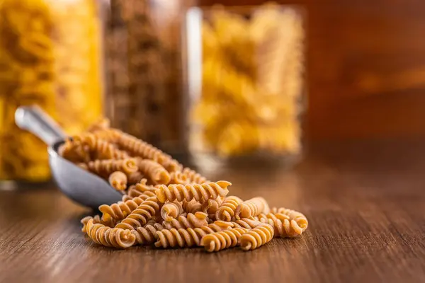 Raw Whole Grain Fusilli Pasta Uncooked Pasta Scoop Wooden Table — Stock Photo, Image