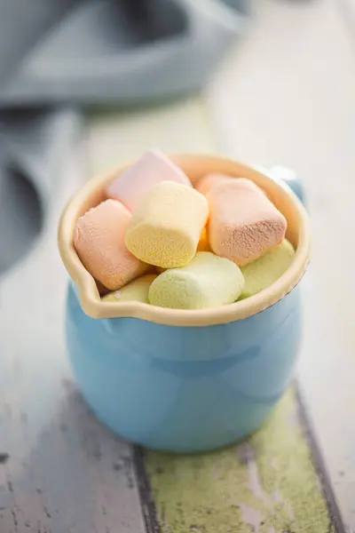 Sweet marshmallows candy in cup on the kitchen table.