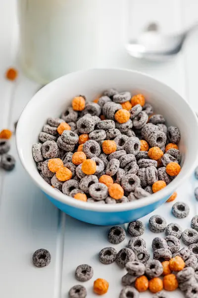 Sweet breakfast cereals in bowl on the white table.