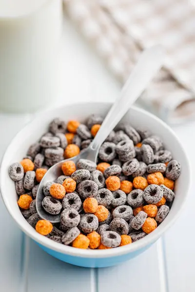 Sweet breakfast cereals in bowl on the white table.