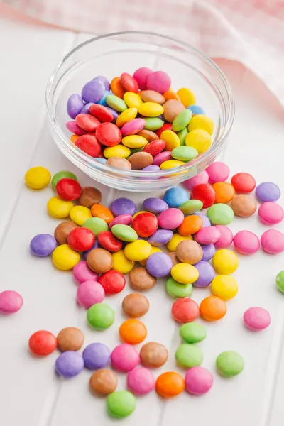 Colorful sweet candies in bowl on the white table.
