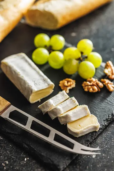 슬레이트 표면에 선명한 포도와 치즈의 상세한 클로즈업 텍스처와 양식을 스톡 사진