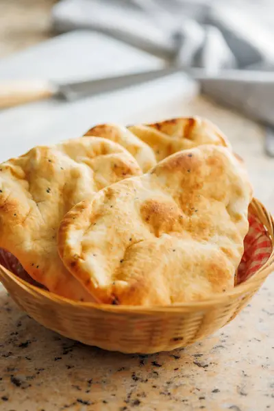 Freshly Baked Naan Bread in basket on a kitchen table.