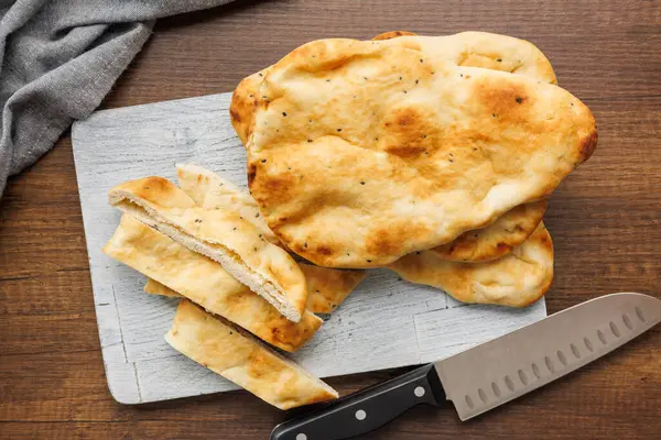 Freshly Baked Naan Bread on cutting board on a wooden table