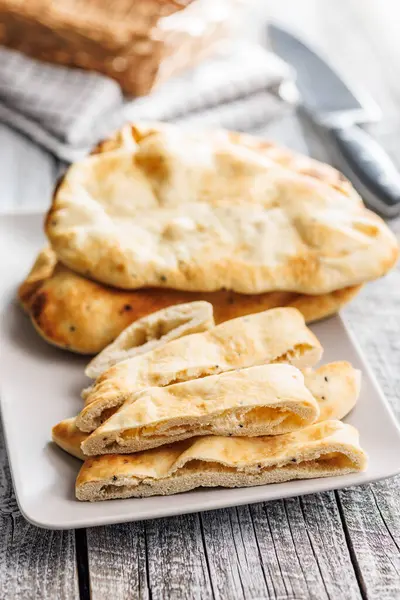 Freshly Baked Naan Bread on plate on a wooden table