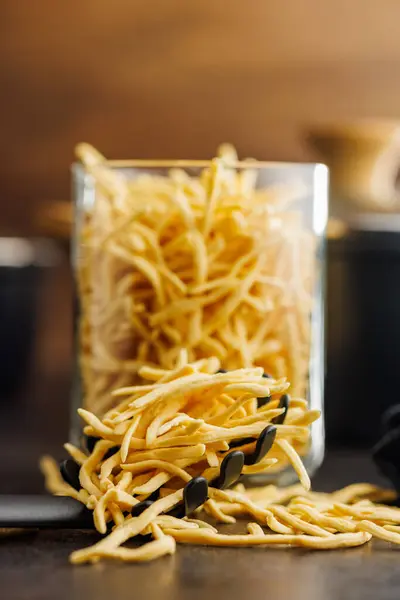 キッチンテーブルで調理されていないスパゲッツルパスタ ロイヤリティフリーのストック画像