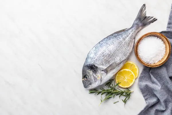 キッチンテーブルの上にフレッシュなシーブラム魚 トップビュー ロイヤリティフリーのストック写真