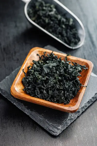 Algues Wakame Séchées Dans Bol Sur Une Table Noire Image En Vente