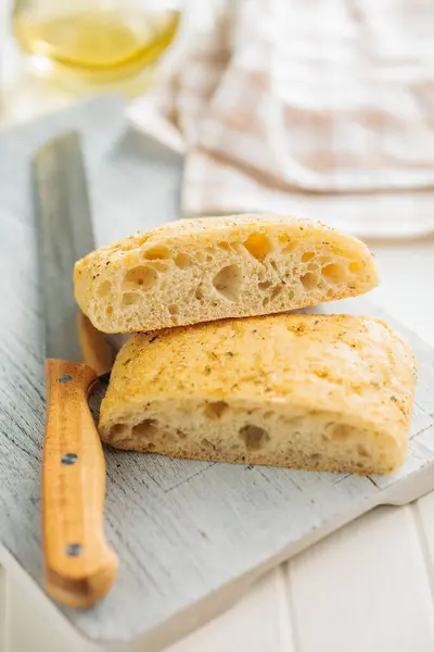 stock image Italian ciabatta bread on cutting board on a white table.