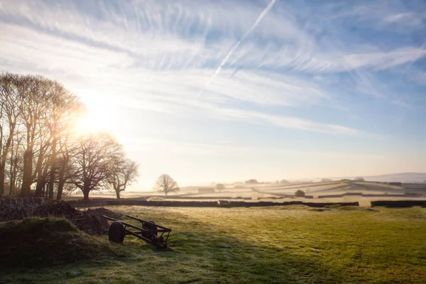 イングランドのピーク地区の早朝の冬の霜の風景とフィールドと石の壁が日の出 ストック写真