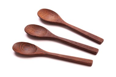 Beyaz arka planda üç siyah tahta kaşık var.