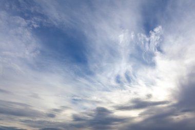 Mavi bir arka planda ince beyaz bulutlar.