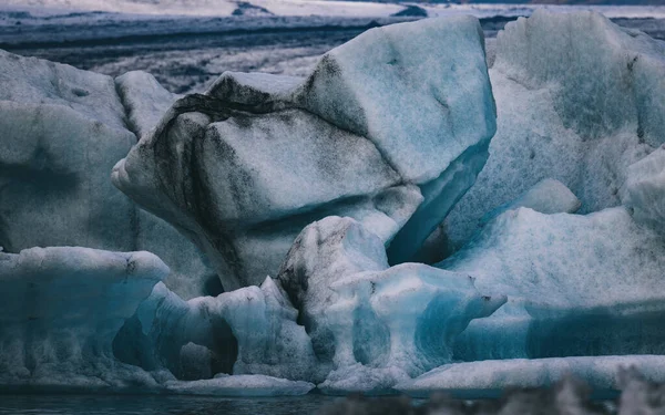 アイスランド南部のジョクルサロン氷河ラグーンにおける青い氷山の抽象的な形 ヴァトナヨークトル国立公園の一部 黒い層は火山灰に閉じ込められている ミュートトーン — ストック写真