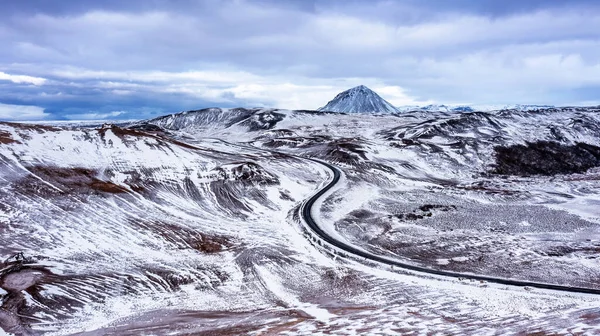 从空中俯瞰一条穿越冰岛北部Hverir地热区的公路 Namafjall在后台 覆盖着雪的冬季场景 — 图库照片