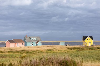 The colourful houses and fishing boats of Havre Aubert, Magdalen Islands, on the gulf of St Lawrence in Canada. clipart