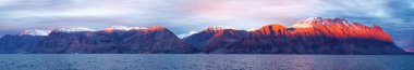 A panorama of the mountains of Antarctic Sound, King Christian X Land, Northeast Greenland National Park, at sunset. clipart