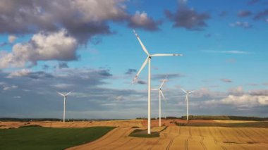 Mavi gökyüzünün üzerindeki çayırlarda rüzgar türbinleri
