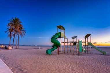 Public playgraound at Playa de las Arenas beach in Valencia at dawn, Spain.