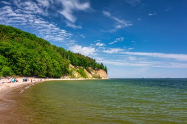 Gdynia, Poland - June 8, 2021: People on the summer beach of the Baltic Sea with cliffs in Gdynia Orlowo, Poland