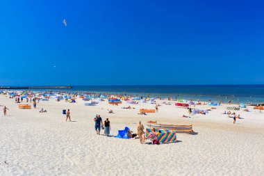 Leba, Polonya - 8 Haziran 2023: Polonya 'nın Leba kentindeki Baltık Denizi yaz plajında turistler. Leba, Polonya 'da Baltık Denizi kıyısında popüler bir turizm beldesi..