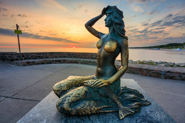 stock image Ustka, Poland - July 8, 2023: Mermaid statue by the Baltic Sea in Ustka at sunrise. Poland