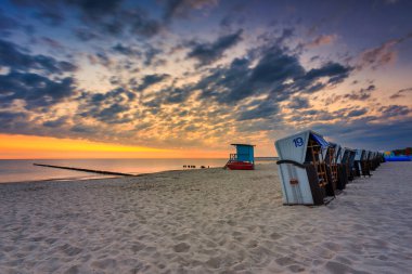 Polonya 'nın Ustka kentindeki Baltık Denizi' nde yaz kumsalında güzel bir gün doğumu..