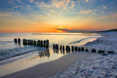 Polonya 'nın Ustka kentindeki Baltık Denizi' nde yaz kumsalında güzel bir gün doğumu..