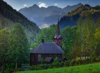 Sabahları ahşap bir kiliseyle Tatra Dağları 'nın güzel manzarası, Slovakya.