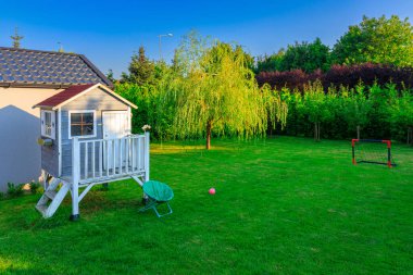 Çocuklar için küçük bir evi olan güzel bir yaz bahçesi.