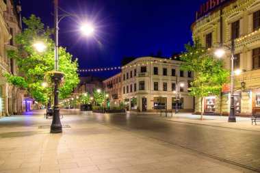 Lodz, Polonya - 24 Ağustos 2023: Lodz şehrindeki Piotrkowska Caddesi 'nin şafak vakti en uzun ticari caddelerden biri olan 4.2 km uzunluğundaki güzel mimarisi. Polonya