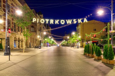 Lodz, Polonya - 24 Ağustos 2023: Lodz şehrindeki Piotrkowska Caddesi 'nin şafak vakti en uzun ticari caddelerden biri olan 4.2 km uzunluğundaki güzel mimarisi. Polonya