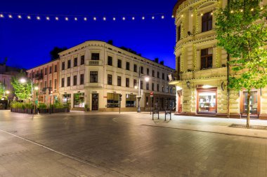 Lodz, Polonya - 24 Ağustos 2023: Lodz şehrindeki Piotrkowska Caddesi 'nin şafak vakti en uzun ticari caddelerden biri olan 4.2 km uzunluğundaki güzel mimarisi. Polonya