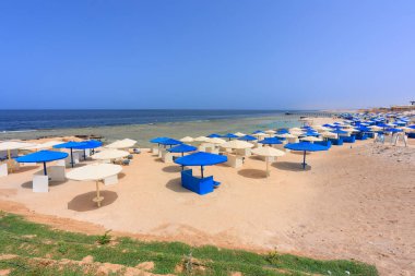 Şemsiyeli güneş pansiyonları güneş doğarken Marsa Alam plajında, Mısır