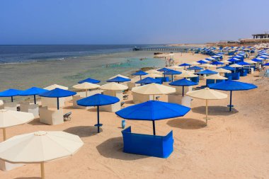 Şemsiyeli güneş pansiyonları güneş doğarken Marsa Alam plajında, Mısır