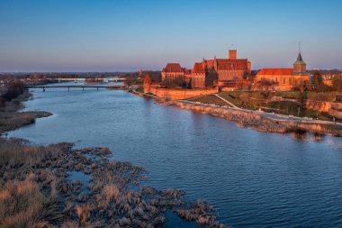 Günbatımında Nogat nehri üzerindeki Malbork kalesi, Polonya