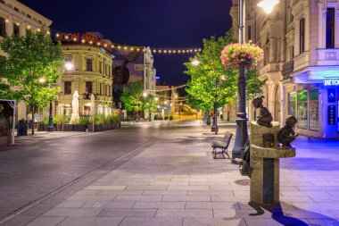 Lodz, Polonya - 24 Ağustos 2023: Lodz şehrindeki Piotrkowska Caddesi 'nin şafak vakti en uzun ticari caddelerden biri olan 4.2 km uzunluğundaki güzel mimarisi. Polonya
