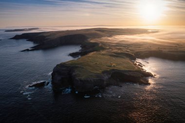 Kilkee, Co. Clare 'in kayalık sahillerinde puslu bir gün doğumu. İrlanda