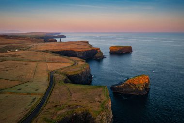 Kilkee, Co. Clare 'in kayalık sahillerinde puslu bir gün doğumu. İrlanda