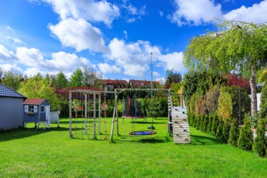Çocuklar için güzel ahşap bir evi ve baharda oyun alanı olan yeşil bir bahçe..