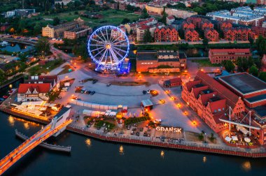 Günbatımında parlayan dönme dolaba sahip ana şehir Gdansk, Polonya.