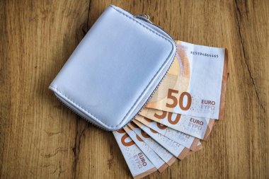 Masasında euro banknotları olan beyaz bir cüzdan.