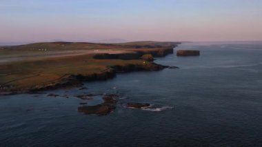 Kilkee, Co. Clare 'in kayalık sahillerinde puslu bir gün doğumu. İrlanda